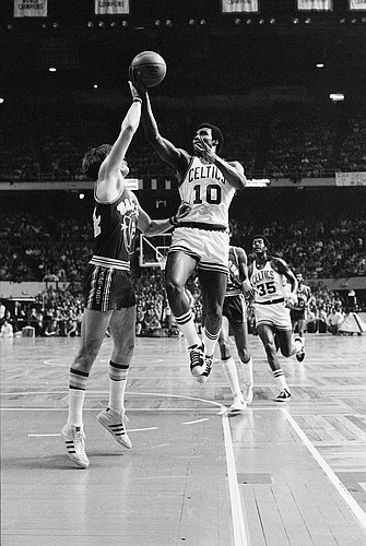 Boston Celtics' Jo Jo White lays up a shot over Golden State Warriors' Rick Barry, in their National Basketball Association game at the Boston Garden, Feb. 29, 1976. Boston won the game 119 to 101. (AP Photo/J. Walter Green)
