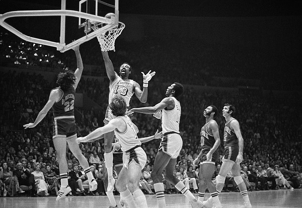 Wilt Chamberlain, named the most valuable player in the NBA playoffs, goes up to tap in a basket for the Los Angeles Lakers against the New York Knicks, May 8, 1972 in the Forum. At left is Dave DeBusschere of the Knicks and in foreground are Pat Riley and Leroy Ellis, right, of the Lakers. Los Angeles won, 114-100, to capture the first championship since the team moved to Los Angeles from Minneapolis 12 years ago. (AP Photo/David Smith)
