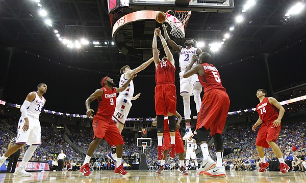 Kansas guard LaGerald Vick (2) and forward Hunter Mickelson (42) fight for a rebound in the paint with members of Team Canada during the third quarter of Friday's World University Games exhibition at Sprint Center.