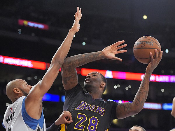 Los Angeles Lakers forward Tarik Black, right, shoots as Minnesota Timberwolves forward Adreian Payne defends during the first half of an NBA basketball game, Friday, April 10, 2015, in Los Angeles. (AP Photo/Mark J. Terrill)