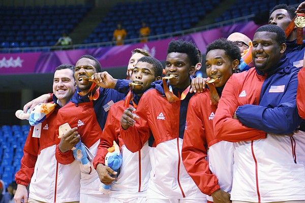 Team USA players bite on their gold medals after a win against Germany Monday, July 13, at the World University Games in South Korea.