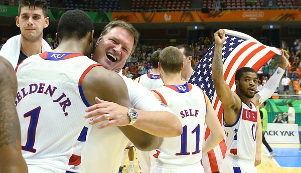 Team USA coach Bill Self, center, hugs Kansas guard Wayne Selden Jr. (1) as Frank Mason III carries an American flag after a Team USA double-overtime win against Germany Monday, July 13, at the World University Games in South Korea.