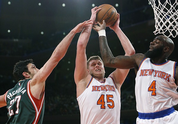 New York Knicks center Cole Aldrich (45) pulls down a rebound as Milwaukee Bucks center Zaza Pachulia (27) defends with New York Knicks forward Quincy Acy (4) getting in on the action in the first half of an NBA basketball game at Madison Square Garden in New York, Sunday, Jan. 4, 2015. (AP Photo/Kathy Willens)