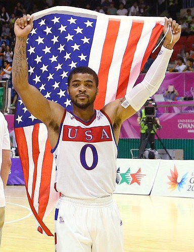 Kansas guard Frank Mason III (0) carries the United States flag after a Team USA double-overtime victory against Germany, Monday, July 13, 2015, at the World University Games in South Korea.