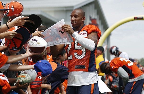 Denver Broncos cornerback Chris Harris signs autographs after drills at the team's NFL football training camp Friday, Aug. 7, 2015, in Englewood, Colo. (AP Photo/David Zalubowski)