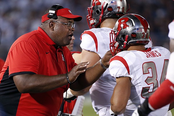 Rutgers interim head coach Norries Wilson, center, talks with Rutgers running back Paul James (34) on the sidelines during the first half of an NCAA college football game against Penn State in State College, Pa., Saturday, Sept. 19, 2015. (AP Photo/Gene J. Puskar)