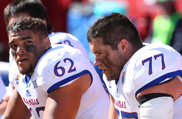 Kansas offensive linemen Joe Gibson (77) and D'Andre Banks (62) catch a breather on the bench during the second quarter on Saturday, Oct. 3, 2015 at Jack Trice Stadium in Ames, Iowa.