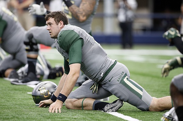 Baylor quarterback Seth Russell stretches with the team during warm ups before an NCAA college football game against Texas Tech Saturday, Oct. 3, 2015, in Arlington, Texas.