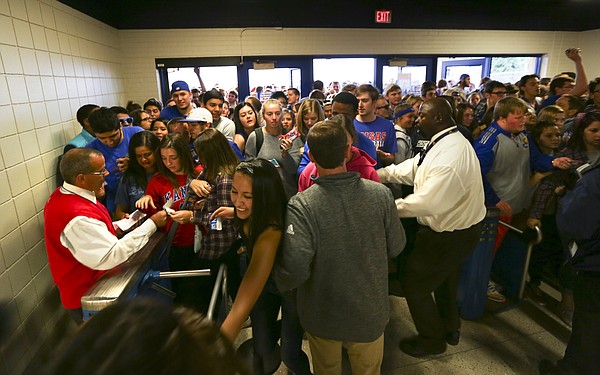 Kansas University students jam through the turnstiles as security workers try to settle the crowd shortly after opening the doors for Late Night in the Phog, Friday, Oct. 9, 2015 at Allen Fieldhouse.