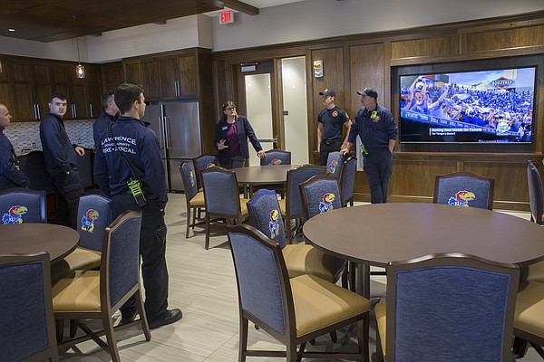 Diana Robertson, director of KU student housing, right, introduces Lawrence-Douglas County Fire and Medical personnel to a multipurpose room and kitchen inside the new $11.2 million McCarthy Hall, which houses the Kansas men's basketball team.