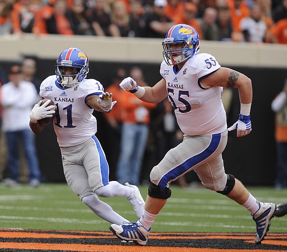 Kansas wide receiver Tre' Parmalee (11) and Kansas offensive lineman Jacob Bragg (55) turn up the field afte a catch in the second quarter on Saturday, Oct. 24, 2015 at T. Boone Pickens Stadium in Stillwater, Okla.
