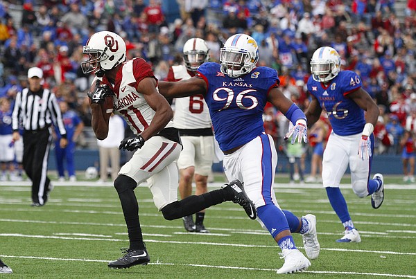 Oklahoma wide receiver Dede Westbrook (11) is snagged by Kansas defensive tackle Daniel Wise (96) during the second quarter, Saturday, Oct. 31, 2015 at Memorial Stadium.