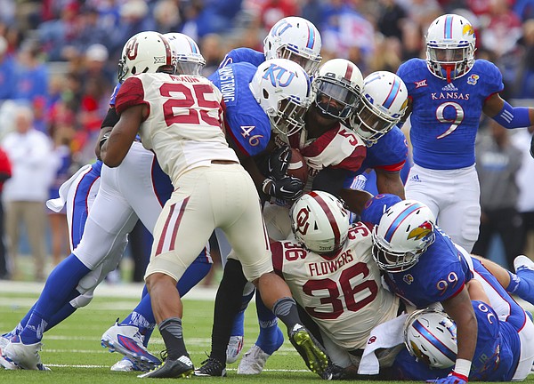 Members of the Kansas defense including Kansas defensive end Dorance Armstrong Jr. (46) bring down Oklahoma wide receiver Durron Neal (5) during the second quarter Saturday, Oct. 31, 2015 at Memorial Stadium.