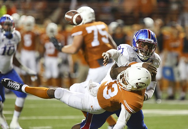 Kansas defensive tackle D.J. Williams (91) lays out Texas quarterback Jerrod Heard (13) and forces a fumble during the second quarter on Saturday, Nov. 7, 2015 at Darrell K. Royal Stadium in Austin, Texas.