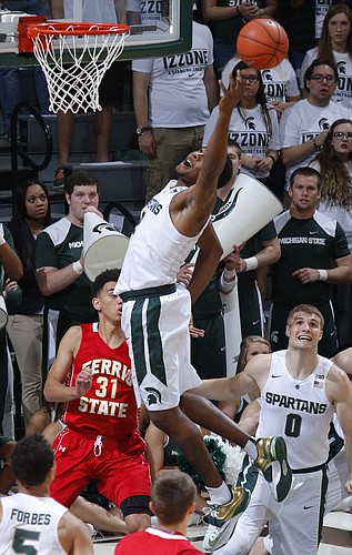 Michigan State's Javon Bess, center, reaches for a rebound over Ferris State's Peter Firlik (32) and Michigan State's Kyle Ahrens (0) during the first half of an NCAA college basketball exhibition game, Monday, Nov. 9, 2015, in East Lansing, Mich. (AP Photo/Al Goldis)