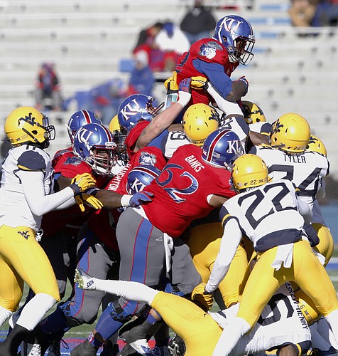 Kansas running back Ke'aun Kinner rides atop his teammates and West Virginia defenders as the Jayhawks push for yards in a 49-0 loss to the Mountaineers Saturday, Nov. 21, 2015, at Memorial Stadium. 