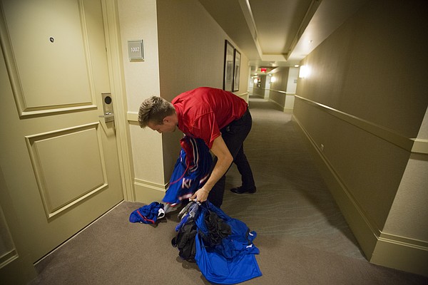 Manager Chip Kueffer retrieves a pile of uniforms left outside a player's room for pickup following the Jayhawks' 123-72 win, Monday, Nov. 23, 2015 at the Westin Maui in Lahaina, Hawaii.