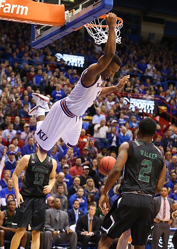 Kansas guard Wayne Selden Jr. (1) hangs on the rim after delivering a dunk against Loyola during the first half, Tuesday, Dec. 1, 2015 at Allen Fieldhouse.