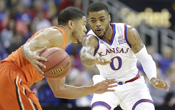 Kansas guard Frank Mason III (0) defends against a drive by Oregon State guard Malcolm Duvivier (11) during the first half, Saturday, Dec. 12, 2015 at Sprint Center.