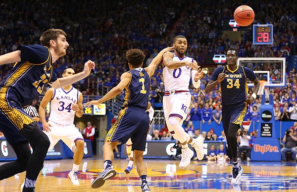 Kansas guard Frank Mason III (0) throws a pass to the wing around UC Irvine guard Alex Young (1) during the second half, Tuesday, Dec. 29, 2015 at Allen Fieldhouse.