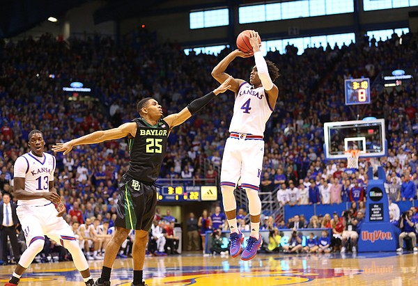 Kansas guard Devonte' Graham (4) pulls up for a three against Baylor guard Al Freeman (25) during the first half, Saturday, Jan. 2, 2016 at Allen Fieldhouse. At left is Kansas forward Cheick Diallo (13).