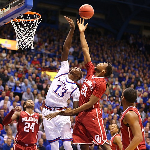 Kansas forward Cheick Diallo (13) tips a rebound out over Oklahoma forward Dante Buford (21) during the first half, Monday, Jan. 4, 2016 at Allen Fieldhouse. Also pictured are Oklahoma guard Buddy Hield (24) and guard Jordan Woodard, right.