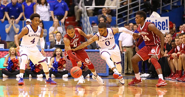 Kansas guard Frank Mason III (0) tries to steal the ball from Oklahoma guard Jordan Woodard (10) during the second half, Monday, Jan. 4, 2016 at Allen Fieldhouse. Also pictured are Kansas guard Devonte' Graham (4) and Oklahoma guard Buddy Hield (24).