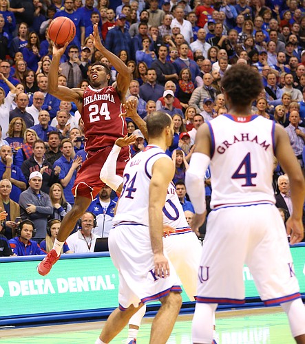 Oklahoma guard Buddy Hield (24) puts up a shot while guarded by Kansas guard Frank Mason III (0) with seconds remaining in the game during the second half, Monday, Jan. 4, 2016 at Allen Fieldhouse.