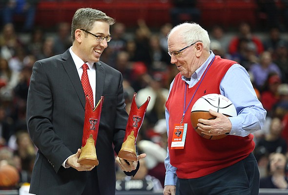 Kansas broadcaster Bob Davis is presented with a pair of Texas Tech cowboy boots by Texas Tech broadcaster Brian Hanni prior to tipoff, Saturday, Jan. 9, 2016 at United Spirit Arena in Lubbock, Texas.