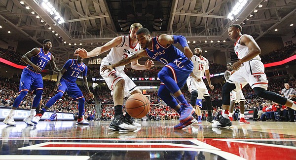Kansas guard Frank Mason III (0) and Texas Tech forward Matthew Temple (34) hustle for a loose ball under the bucket during the first half, Saturday, Jan. 9, 2016 at United Spirit Arena in Lubbock, Texas.