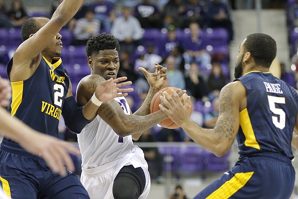 TCU guard Chauncey Collins (1) battles West Virginia guards Jevon Carter (2) and Jaysean Paige (5) for space during the second half of an NCAA college basketball game Monday, Jan. 4, 2016, in Fort Worth, Texas. (AP Photo/Brandon Wade)