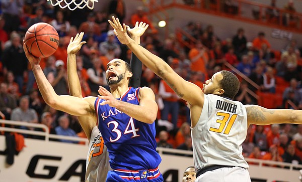 Kansas forward Perry Ellis (34) heads to the bucket past Oklahoma State forward Chris Olivier (31) during the second half, Tuesday, Jan. 19, 2016 at Gallagher-Iba Arena in Stillwater, Okla.