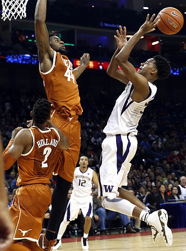 Dejounte Murray of the Washington Huskies tries to throw past Prince Ibeh of the Texas Longhorns during a match at the Mercedes Benz Arena in Shanghai, China, Saturday, Nov. 14, 2015. The University of Texas and University of Washington played the first-ever regular-season college men's basketball game in China at Shanghai's Mercedes Benz Arena, organized by the Pac-12 conference in partnership with Chinese tech giant Alibaba Group. (AP Photo/Ng Han Guan)
