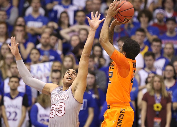 Kansas forward Landen Lucas (33) gets in the face of Oklahoma State guard Jeff Newberry (22) on a shot during the second half, Monday, Feb. 15, 2016 at Allen Fieldhouse.