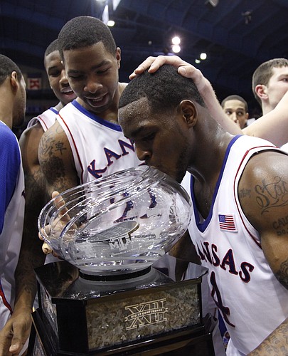 Kansas guard Sherron Collins kisses the Big 12 championship trophy after the Jayhawks' win over Oklahoma, Monday, Feb. 22, 2010 at Allen Fieldhouse. In back is Kansas forward Marcus Morris.