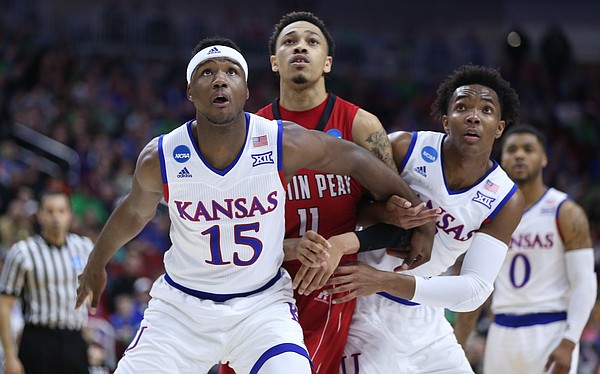 Kansas forward Carlton Bragg Jr. (15) and guard Devonte' Graham (4) box out Austin Peay guard Khalil Davis (11) during the first half of a first-round NCAA Tournament game, Thursday, March 17, 2016 at Wells Fargo Arena in Des Moines, Iowa.