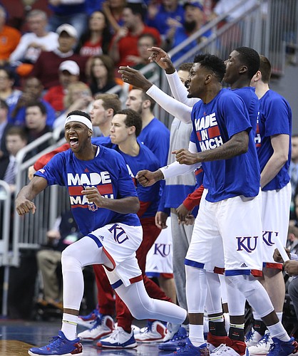 Kansas forward Carlton Bragg Jr., left, and players on the Jayhawks' bench erupt in the second half after a three by KU guard Wayne Selden Jr., Thursday, March 24, 2016 at KFC Yum! Center in Louisville, Ky.
