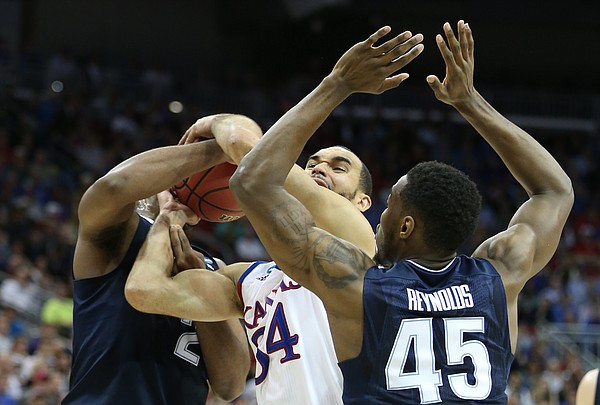 Kansas forward Perry Ellis (34) gets tied up with Villanova forward Kris Jenkins (2) and forward Darryl Reynolds (45) during the first half, Saturday, March 26, 2016 at KFC Yum! Center in Louisville, Kentucky.