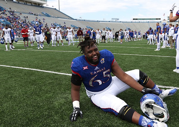 Kansas offensive lineman Jayson Rhodes (65) picks himself off the ground after falling down laughing while fellow lineman field kickoffs during the Spring Game on Saturday, April 9, 2016 at Memorial Stadium.