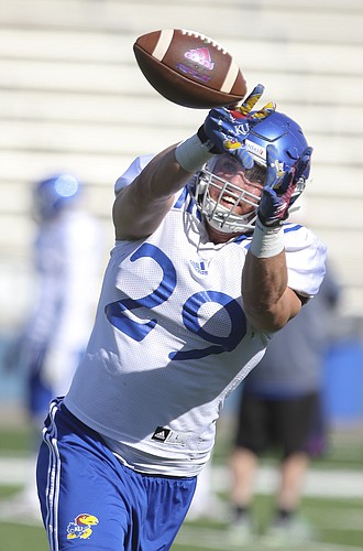 Kansas linebacker Joe Dineen Jr. (29) reaches for a catch during practice on Tuesday, April 11, 2016 at Memorial Stadium.