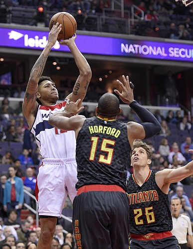 Washington Wizards forward Kelly Oubre Jr., left, takes a shot against Atlanta Hawks center Al Horford (15) and guard Kyle Korver (26) during the first half of an NBA basketball game, Wednesday, April 13, 2016, in Washington. (AP Photo/Nick Wass)