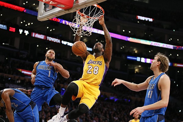 Los Angeles Lakers' Tarik Black dunks in front of Dallas Mavericks' Justin Anderson, left, and Dirk Nowitzki, right, during the second half of an NBA basketball game, Tuesday, Jan. 26, 2016, in Los Angeles. The Mavericks won 92-90. (AP Photo/Danny Moloshok)