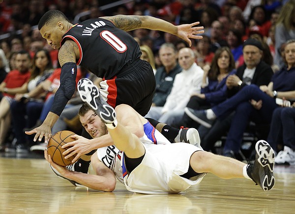 Los Angeles Clippers' Cole Aldrich, bottom, gets the ball against Portland Trail Blazers' Damian Lillard in the second half in Game 1 of a first-round NBA basketball playoff series Sunday, April 17, 2016, in Los Angeles. The Clippers won 115-95. (AP Photo/Jae C. Hong)