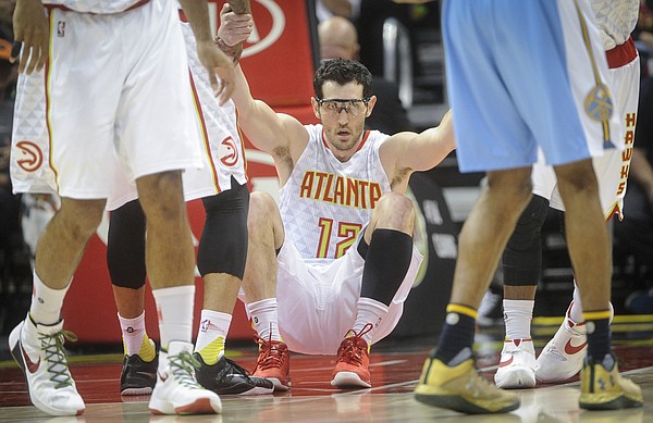 Atlanta Hawks guard Kirk Hinrich (12) is helped up after taking a charge against the Denver Nuggets during an NBA basketball game, Thursday, March 17, 2016, in Atlanta. Atlanta won 116-98.(AP Photo/John Amis)