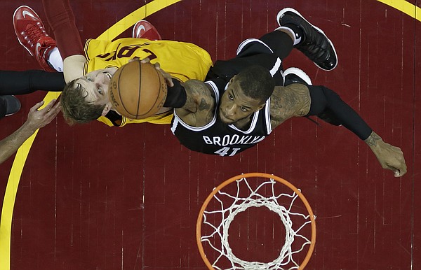 Cleveland Cavaliers' Timofey Mozgov, left, from Russia, and Brooklyn Nets' Thomas Robinson battle for a rebound in the second half of an NBA basketball game Thursday, March 31, 2016, in Cleveland. (AP Photo/Tony Dejak)