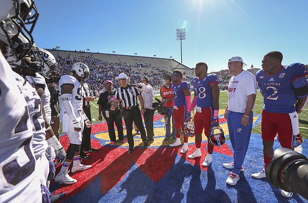 The Jayhawk and Horned Frog captains meet at midfield for the coin toss prior to Saturday's game. On hand to flip the coin as part of "Jayhawks for a Cure" day was Carla Arnick,  standing behind the official, who is a breast cancer survivor and mother of Kansas linebacker Courtney Arnick, third from right.