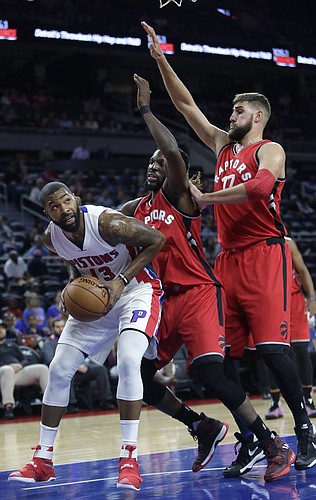 Detroit Pistons' Marcus Morris (13) tries to go to the basket against Toronto Raptors' DeMarre Carroll, center, and Jonas Valanciunas during the first half of an NBA preseason basketball game Wednesday, Oct. 19, 2016, in Auburn Hills, Mich. (AP Photo/Duane Burleson)