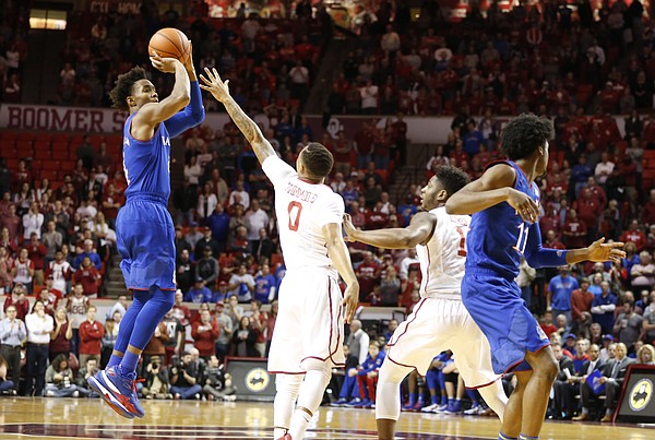 Kansas guard Devonte' Graham (4) pulls up for a three over Oklahoma guard Darrion Strong-Moore (0) during the first half, Tuesday, Jan. 10, 2017 at Lloyd Noble Center in Norman, Okla.
