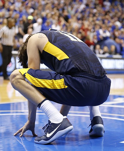 West Virginia forward Nathan Adrian (11) reacts after losing a ball off of his knee during overtime, Monday, Feb. 13, 2017 at Allen Fieldhouse.