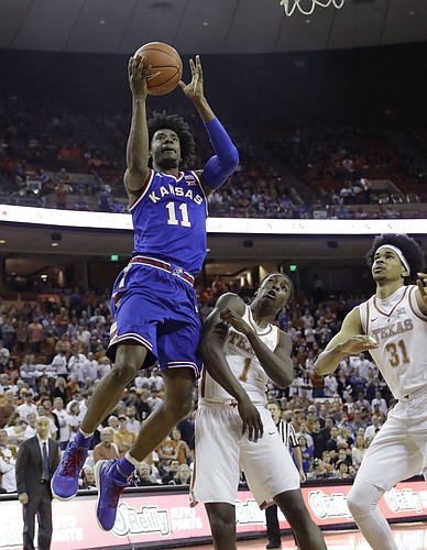 Kansas guard Josh Jackson (11) shoots over Texas defenders Andrew Jones (1) and Jarrett Allen (31) during the first half of an NCAA college basketball game, Saturday, Feb. 25, 2017, in Austin, Texas.